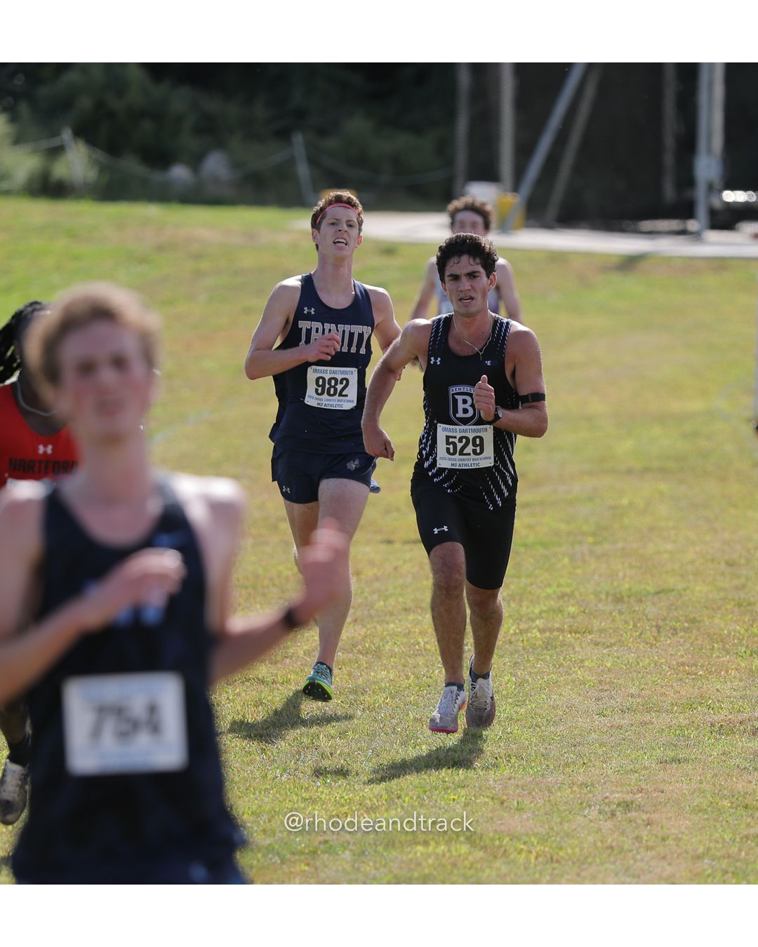 #982 Mark Kanner, Trinity (Conn.), 8k Run - Men (Navy-45:cap), P36, 27:07.49; #529 Matthew McDevitt, Bentley, 8k Run - Men (Navy-45:cap), P35, 27:07.07 - 2026 UMass Dartmouth XC Invitational - UMass Dartmouth - Dartmouth, Massachusetts - September 19, 2026 File: ./260919-2026-UMass-Dartmouth-XC-Invitational-21-398A3935.jpg #982 Mark Kanner, Trinity (Conn.), 8k Run - Men (Navy-45:cap), P36, 27:07.49; #529 Matthew McDevitt, Bentley, 8k Run - Men (Navy-45:cap), P…